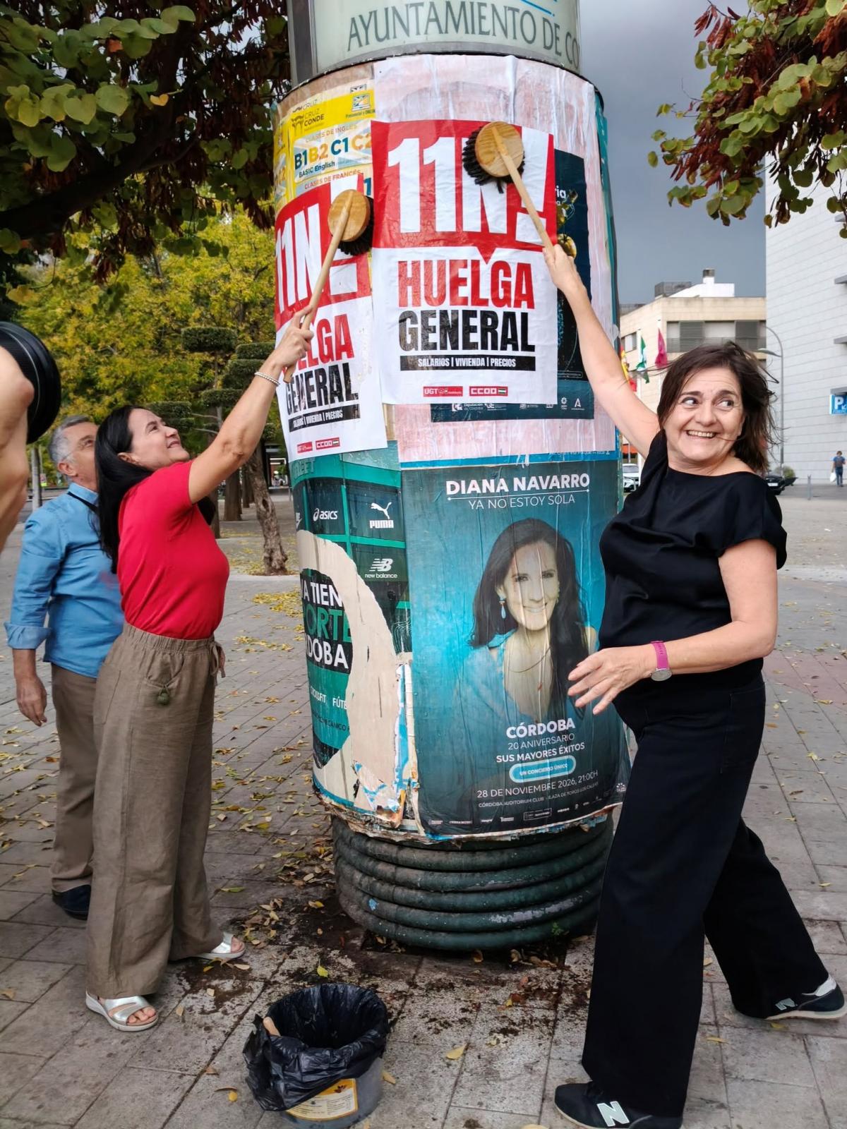 Las secretarias generales de CCOO y UGT pegando los primeros carteles de la huelga general del 11 de noviembre.