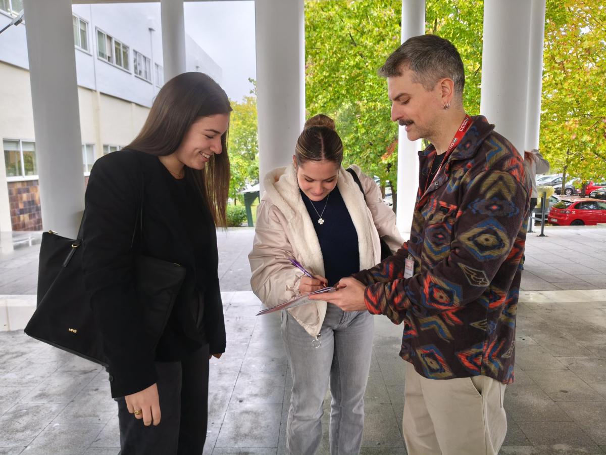 Dos estudiantes de la Facultad de CC. de la Educación y Psicología firmando la petición de CCOO a la Consejería de Justicia.